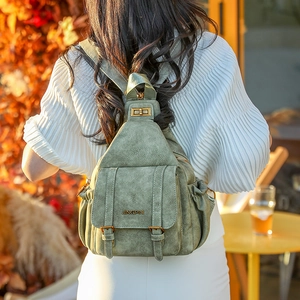 Detailed view of sage green soft faux leather backpack with metallic buckle and front pocket