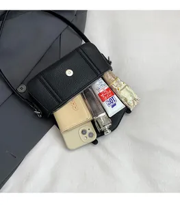 Interior espacioso del bolso bandolera de piel negra con cierre magnético para esenciales