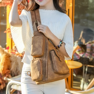 Detalle del bolso de pecho vintage marrón con cremalleras y hebillas metálicas