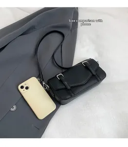 Bolso bandolera con patrón de lichi y un smartphone para comparar el tamaño