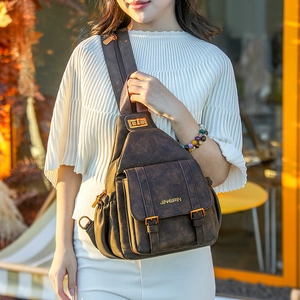 Detail of vintage brown soft leather chest bag showing metal buckle and front pocket