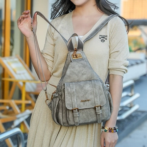Detail of grey vintage soft PU leather backpack with magnetic flap and metal hardware