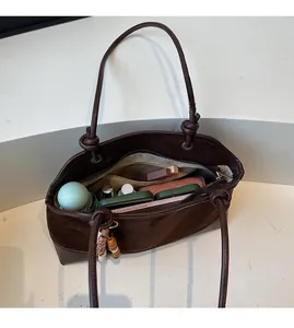 Intérieur spacieux du sac cabas en cuir marron foncé avec poches et fermeture éclair