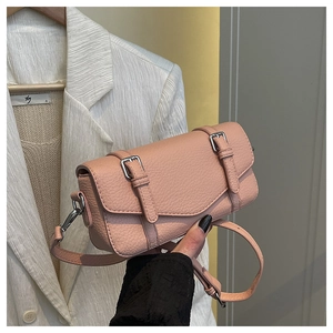 Detalle de bolso bandolera rosa en cuero granulado con hebillas plateadas y estilo retro
