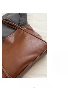 Detail of soft brown faux leather texture and sturdy stitching on a tote shoulder bag
