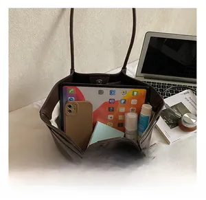 Spacious interior of brown leather tote bag holding a tablet, phone, and daily essentials