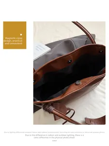 Detailed close-up of a large tote bag with magnetic snap closure and soft leather texture