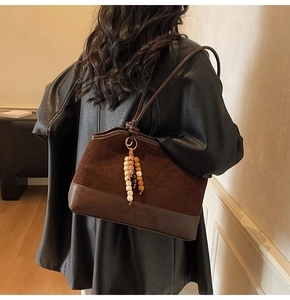 Dettaglio della borsa tote vintage con trame miste e nodo decorativo con perline