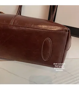 Detailed close-up of the vintage brown leather tote bag's protective bottom foot pad