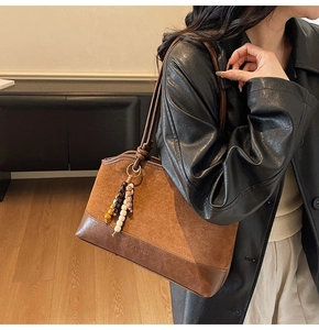 Dettaglio della borsa tote marrone vintage con texture mista in camoscio e pelle