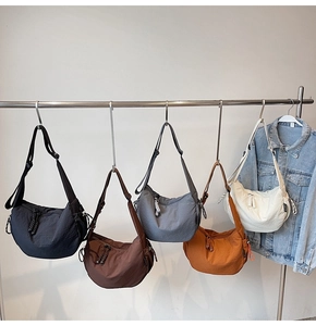 Detailansicht von fünf karierten Canvas-Halbmondtaschen in verschiedenen Farben am Display