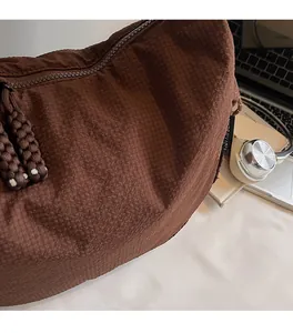 Nahaufnahme der braunen Canvas-Tasche mit Waffelstruktur, Reißverschluss und Laptop