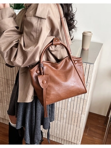 Brown PU leather tote bag styled with a beige trench coat for a chic daily commute look
