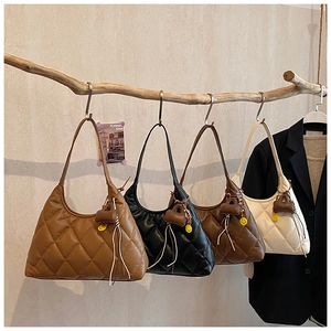 Close-up of quilted pattern shoulder bags in four colors with cute smiley pendants