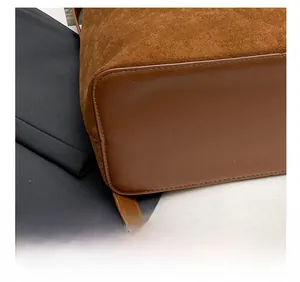 Detailed macro view showing the precision stitching on the brown suede bucket bag base