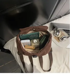 Spacious interior of brown quilted nylon backpack showing tablet, wallet, and water bottle