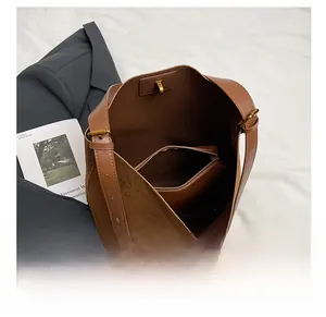 Detail view of large brown tote bag with leather patchwork and inner zipper pouch