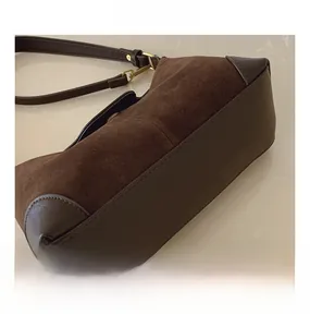 Detail of brown suede and leather splicing with golden metal buckle on the bag