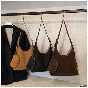 Three leather hobo bags in tan, black, and brown hanging with matching coin purses