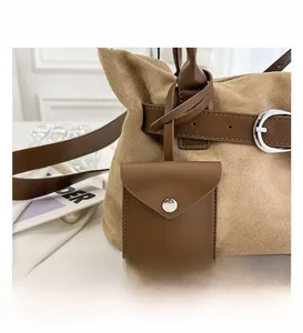 Close-up of khaki suede tote bag with brown leather belt detail and silver metal buckle