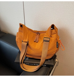 Detail der karamellfarbenen Segeltuchtasche mit Waffelstruktur und breitem Schultergurt