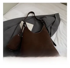 Detail of dark brown suede hobo bag with adjustable strap and small zipper pouch
