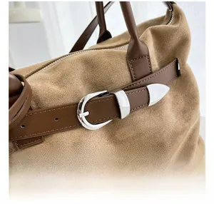 Close-up of premium silver horseshoe buckle and stitching on khaki suede tote bag