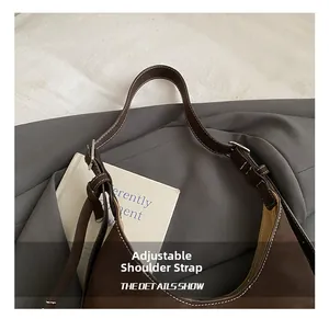 Detail of adjustable shoulder strap with silver buckle on vintage brown leather tote bag