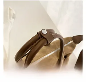 Detail of comfortable brown tote handle with metal snap fastener and silver zipper