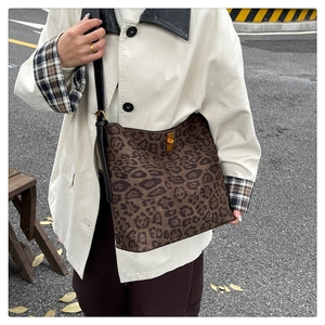 Detail of leopard print tote bag with black leather strap and gold metallic buckle clasp