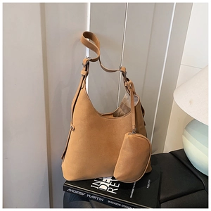 Detail of a caramel suede tote bag with a matching coin purse and silver hardware