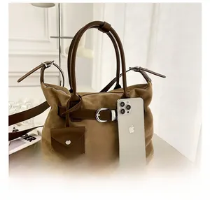 Detailed comparison of the brown suede tote bag size alongside a smartphone