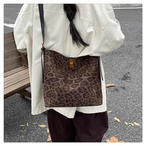 Detail of leopard print tote bag with golden twist lock and slim black shoulder strap
