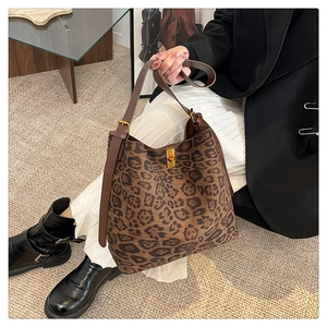 Detail of leopard print tote bag with brown leather strap and gold metal hardware
