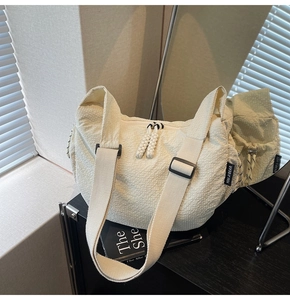 Detail der cremefarbenen Stofftasche mit 3D-Blasenstruktur und gewebten Zippern