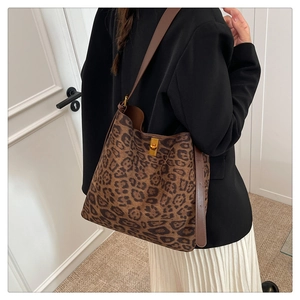Detailed shot of leopard print suede tote bag with brown leather strap and gold clasp