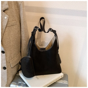 Detail of black suede tote bag with silver buckle and matching small coin purse hanging