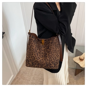 Close-up of leopard print bucket bag with gold metal twist lock and brown leather strap