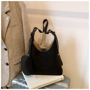 Detail of black suede hobo bag with contrast stitching and inner yellow lining