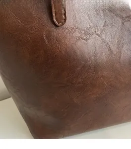 Close-up of vintage brown tote bag showing soft lychee grain leather texture details