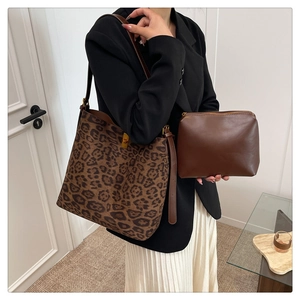 Macro shot of leopard print bucket bag and brown leather clutch set for women