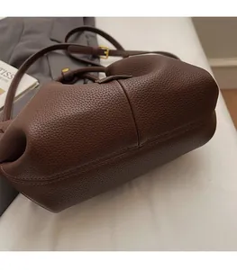 Detailed view of dark brown lychee grain leather handbag with vintage gold hardware