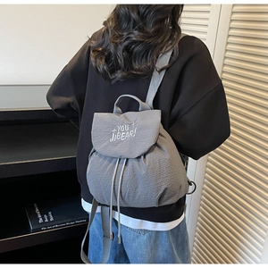 Grey bubble texture backpack featuring a drawstring flap and white letter embroidery
