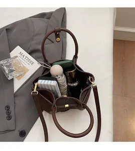 Top-down view of the spacious interior of a brown pebbled leather bucket bag with daily items