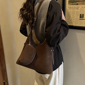 Detail of a brown suede hobo bag with a matching small coin purse and slim strap
