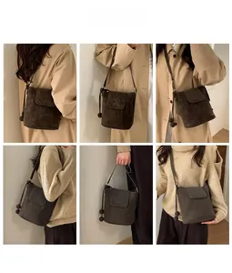 Détail du sac seau en daim marron montrant le rabat et les breloques à billes