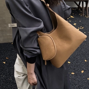 Detail of a brown suede hobo bag with a matching small pouch for autumn styling