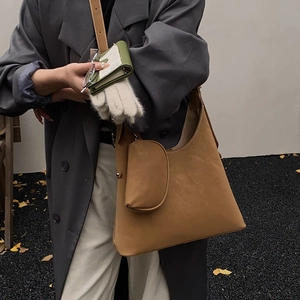 Caramel brown oversized slouchy shoulder bag with matching mini pouch in autumn street style