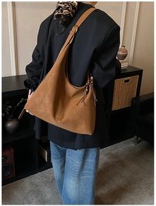 Chic caramel brown tote bag with vintage wood bead tassel on stylish black blazer