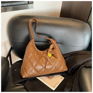 Brown quilted hobo bag with diamond pattern on a black leather chair with accessories